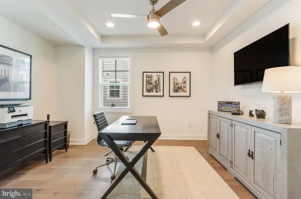 a kitchen with stainless steel appliances granite countertop a stove a sink dishwasher and white cabinets with wooden floor