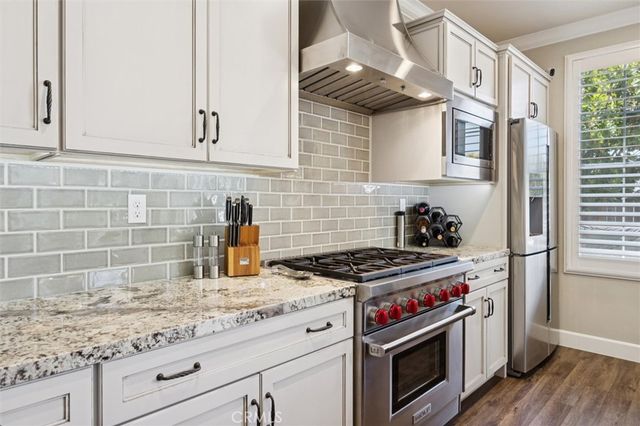 a kitchen with a stove a kitchen island a dining table and chairs