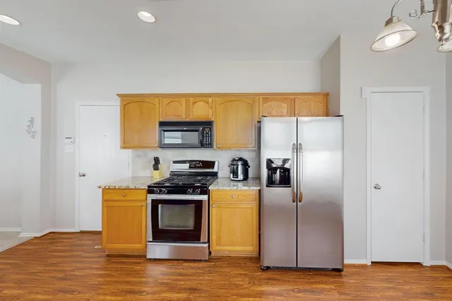 a kitchen with stainless steel appliances a refrigerator and a stove top oven
