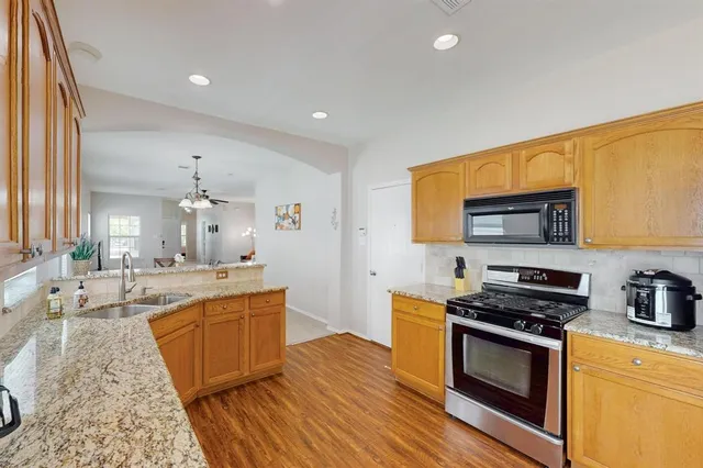 a kitchen with stainless steel appliances granite countertop a stove a sink and a refrigerator