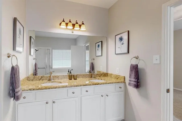 a bathroom with a granite countertop sink and a mirror