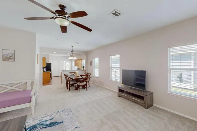 a living room with furniture a window and a flat screen tv