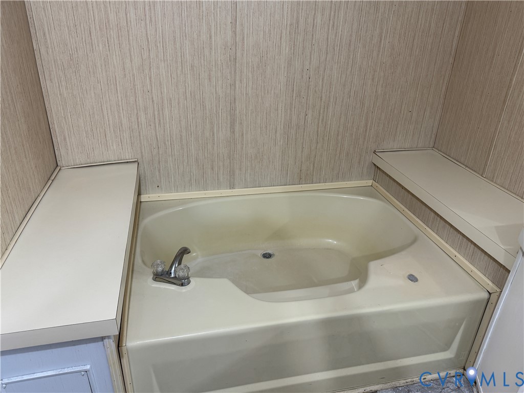 371 Horseshoe Road Jarratt, VA 23867 - Photo 17 of 21 a bath tub sitting next to a white sink and vanity