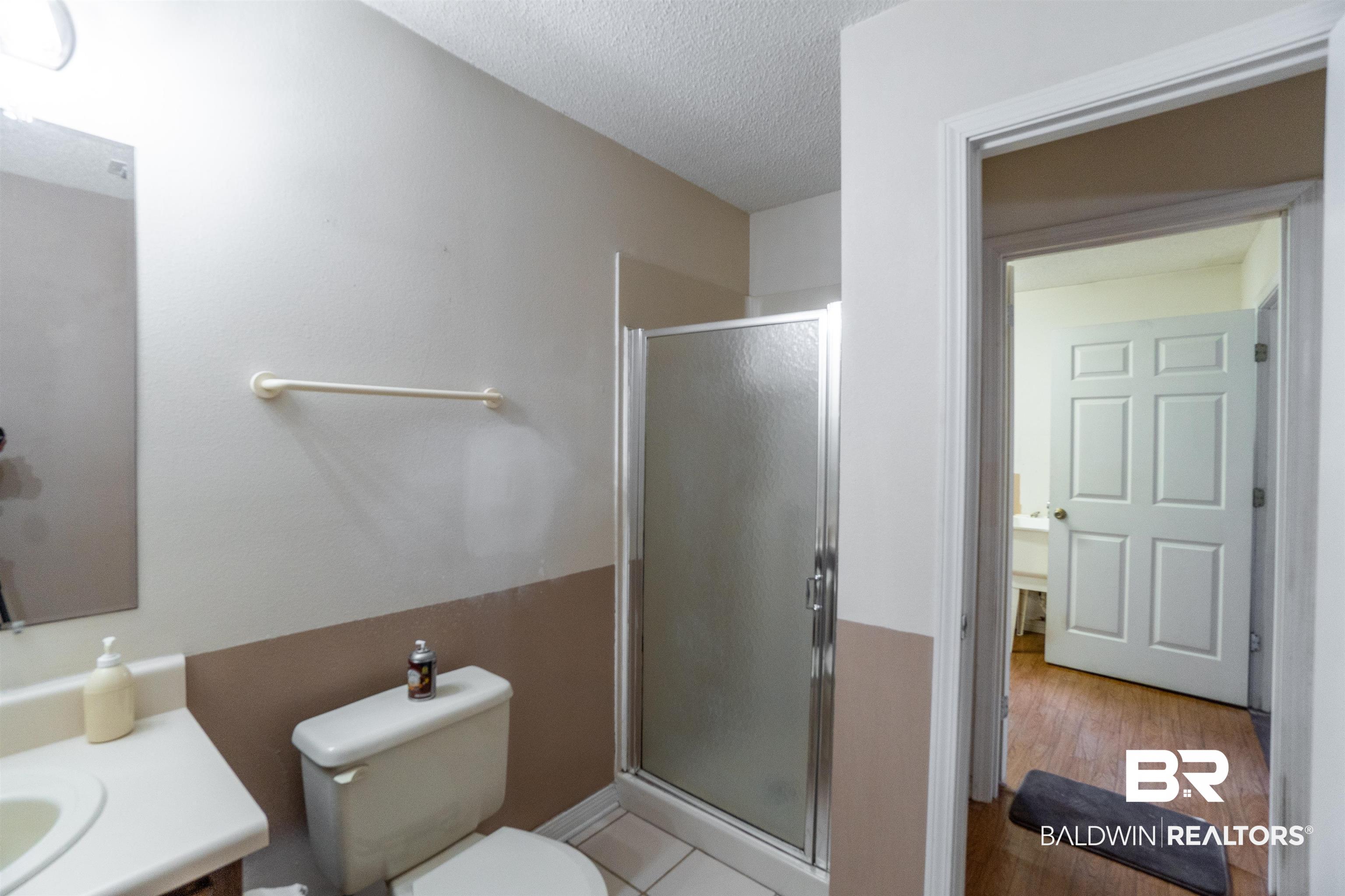 10349 Longview Drive West Foley, AL 36535 - Photo 26 of 35 Bathroom featuring a textured ceiling, an enclosed shower, toilet, vanity, and wood-type flooring