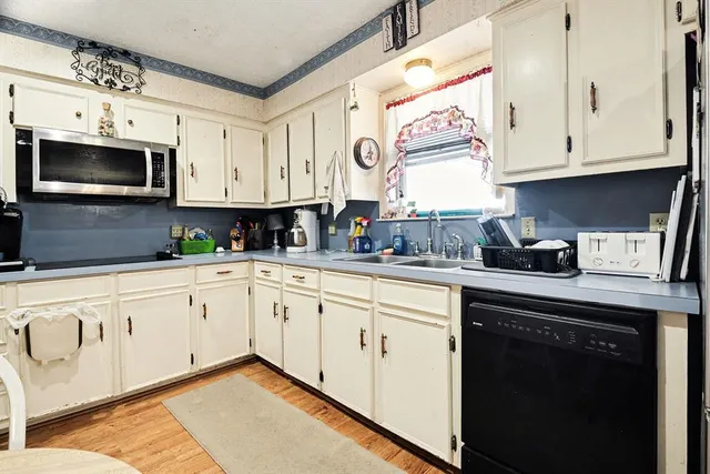 a kitchen with stainless steel appliances kitchen island granite countertop a stove a refrigerator and a dining table with wooden floor