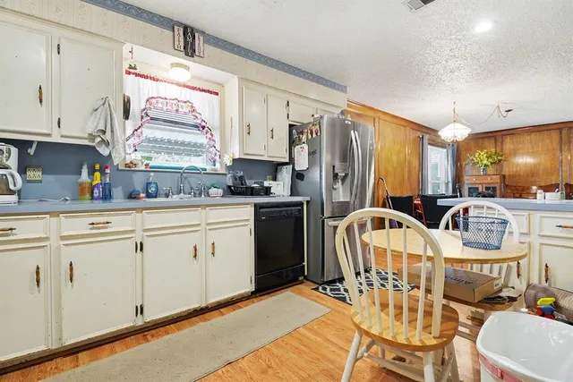 a living room with furniture a dining table and chairs with wooden floor