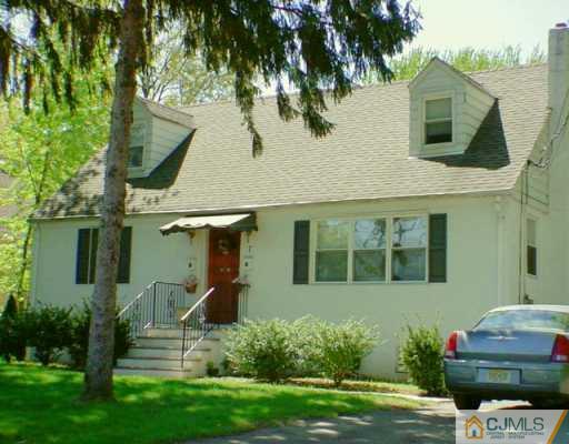 7 Morningside Road Colonia, NJ 07067 - Photo 1 of 2 a front view of a house with a garden and trees