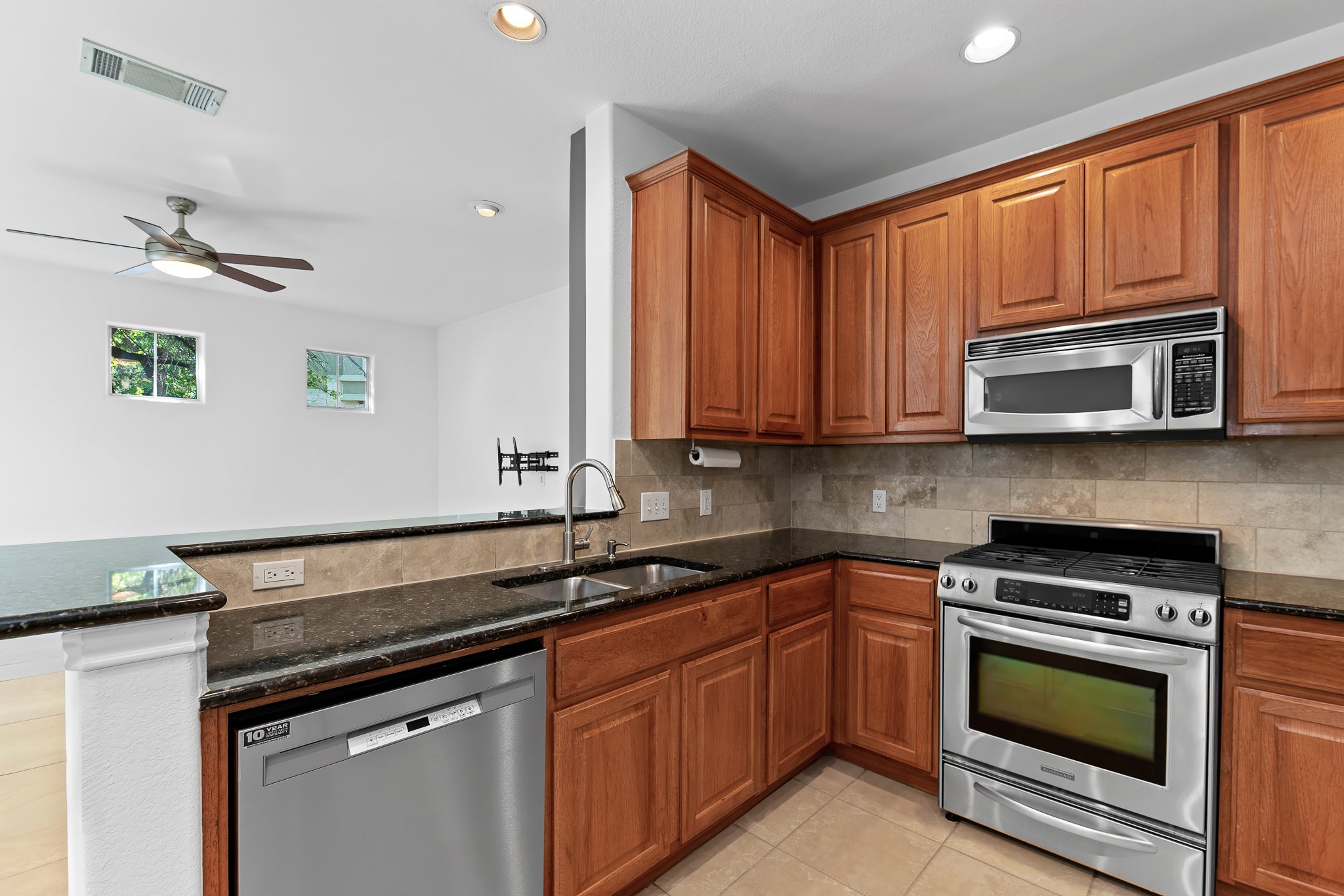 3406 Menchaca Road, Unit 28 Austin, TX 78704 - Photo 14 of 40 Kitchen with stainless steel appliances, dark stone countertops, wood finish cabinets, and recessed lighting