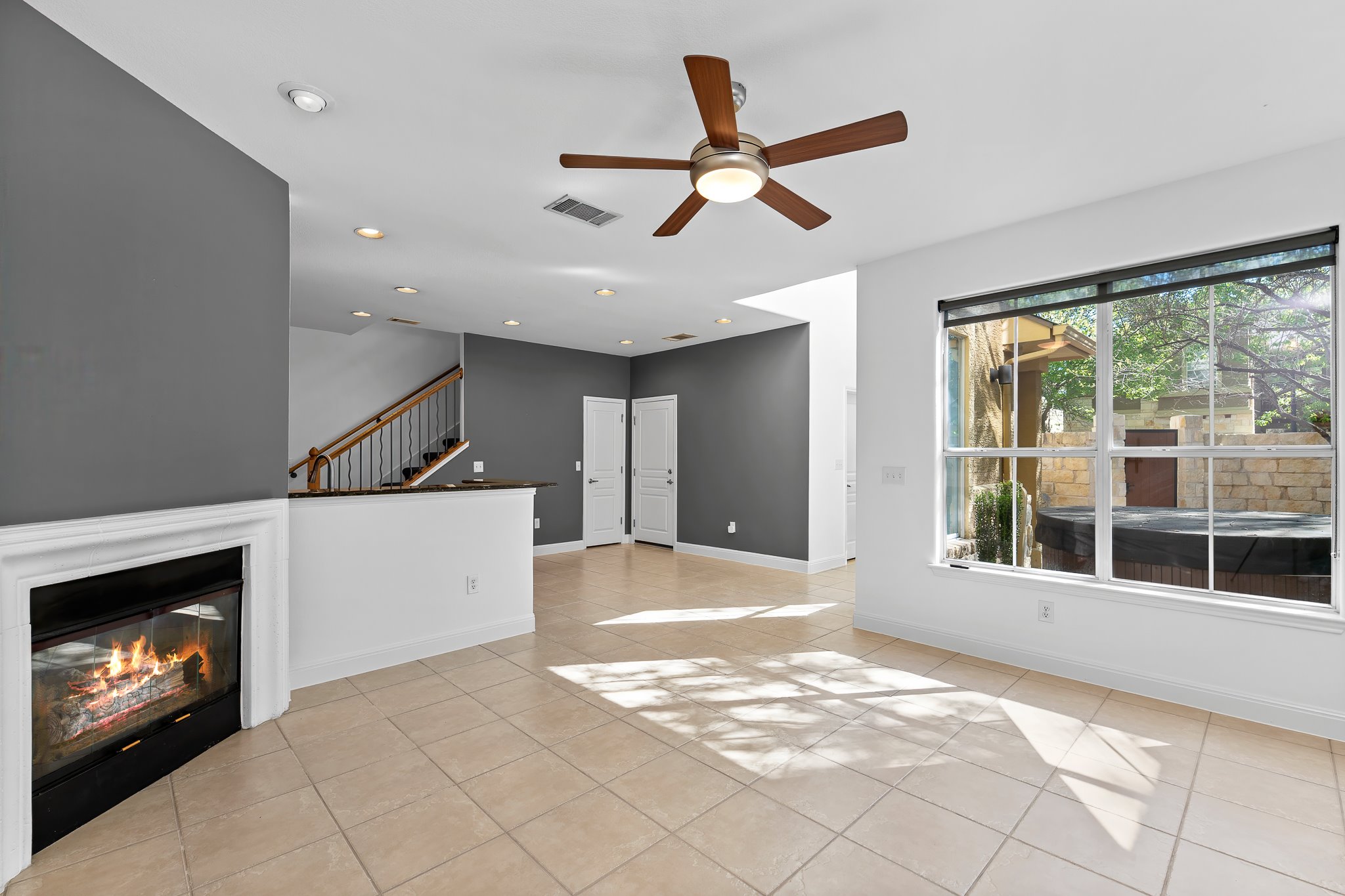 3406 Menchaca Road, Unit 28 Austin, TX 78704 - Photo 20 of 40 Unfurnished living room with light tile patterned floors, ceiling fan, a glass covered fireplace, and recessed lighting