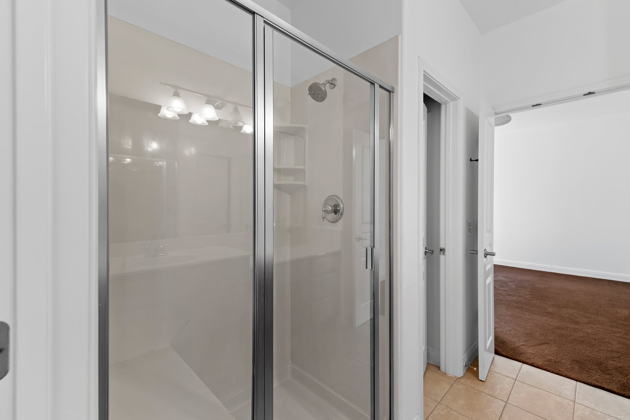 3406 Menchaca Road, Unit 28 Austin, TX 78704 - Photo 29 of 40 Full bathroom with light colored carpet, a shower stall, and light tile patterned flooring