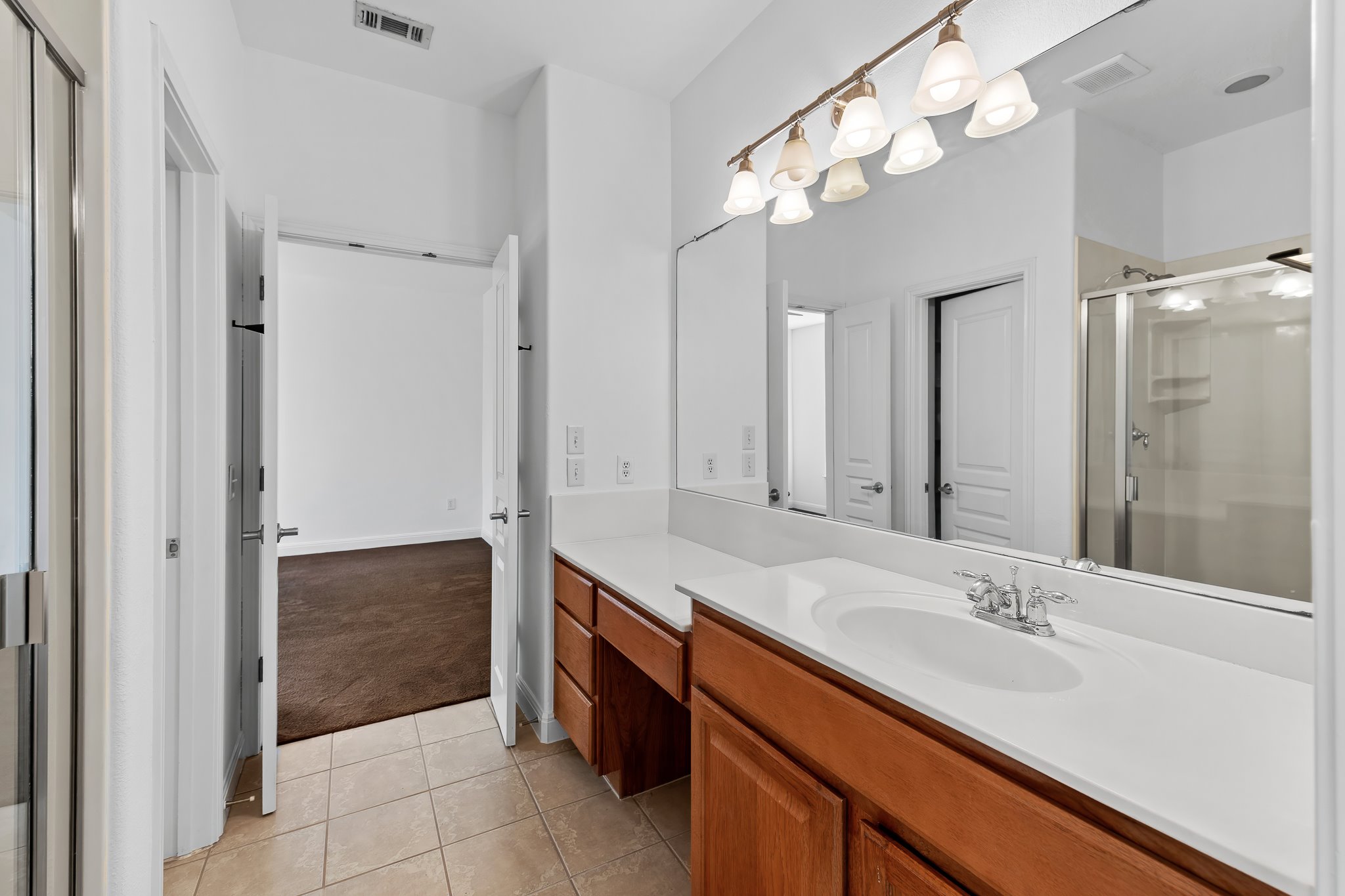 3406 Menchaca Road, Unit 28 Austin, TX 78704 - Photo 31 of 40 Full bathroom featuring a stall shower, vanity, light carpet, and light tile patterned floors