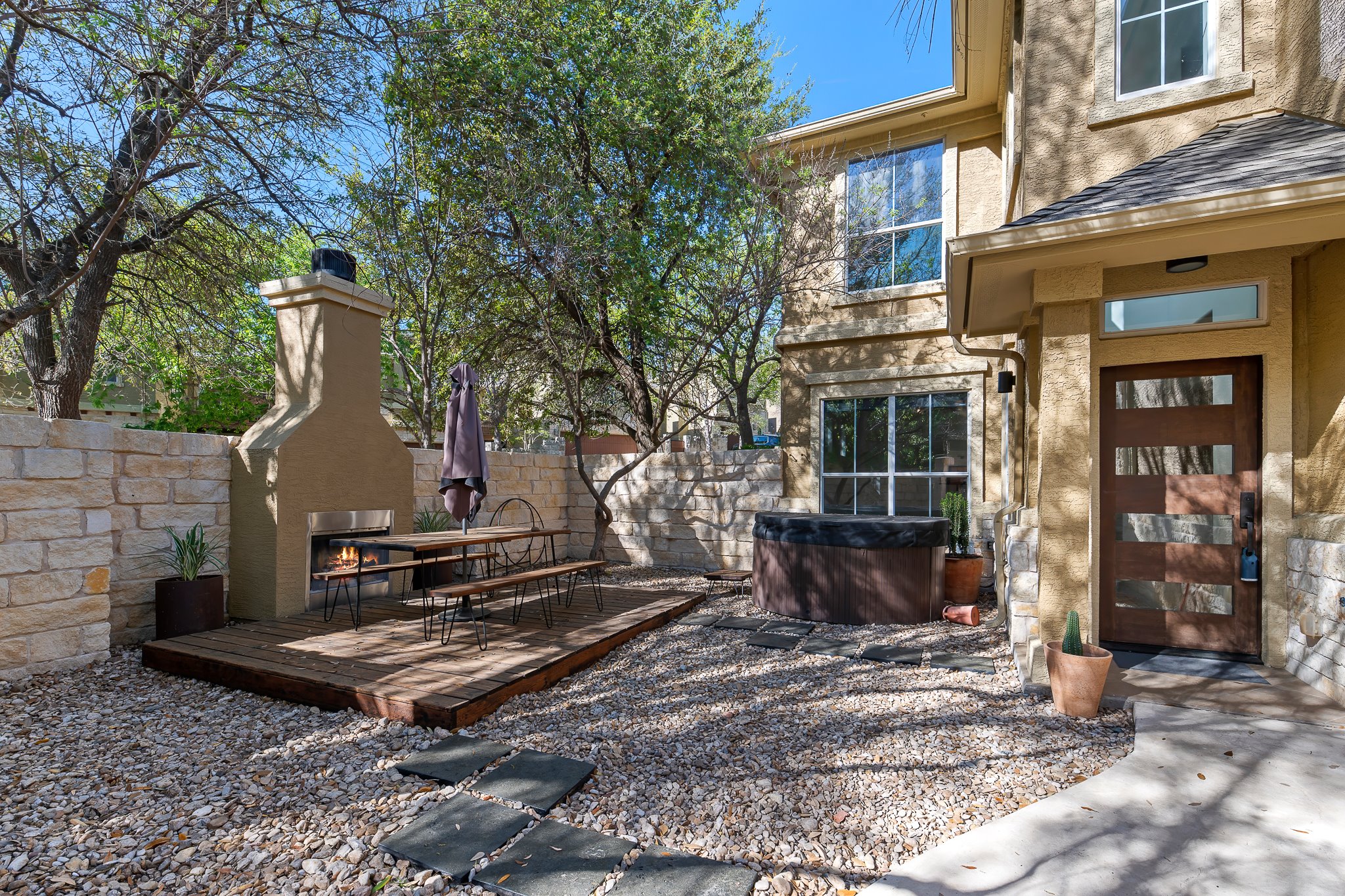 3406 Menchaca Road, Unit 28 Austin, TX 78704 - Photo 7 of 40 View of patio with a warm lit fireplace and a deck