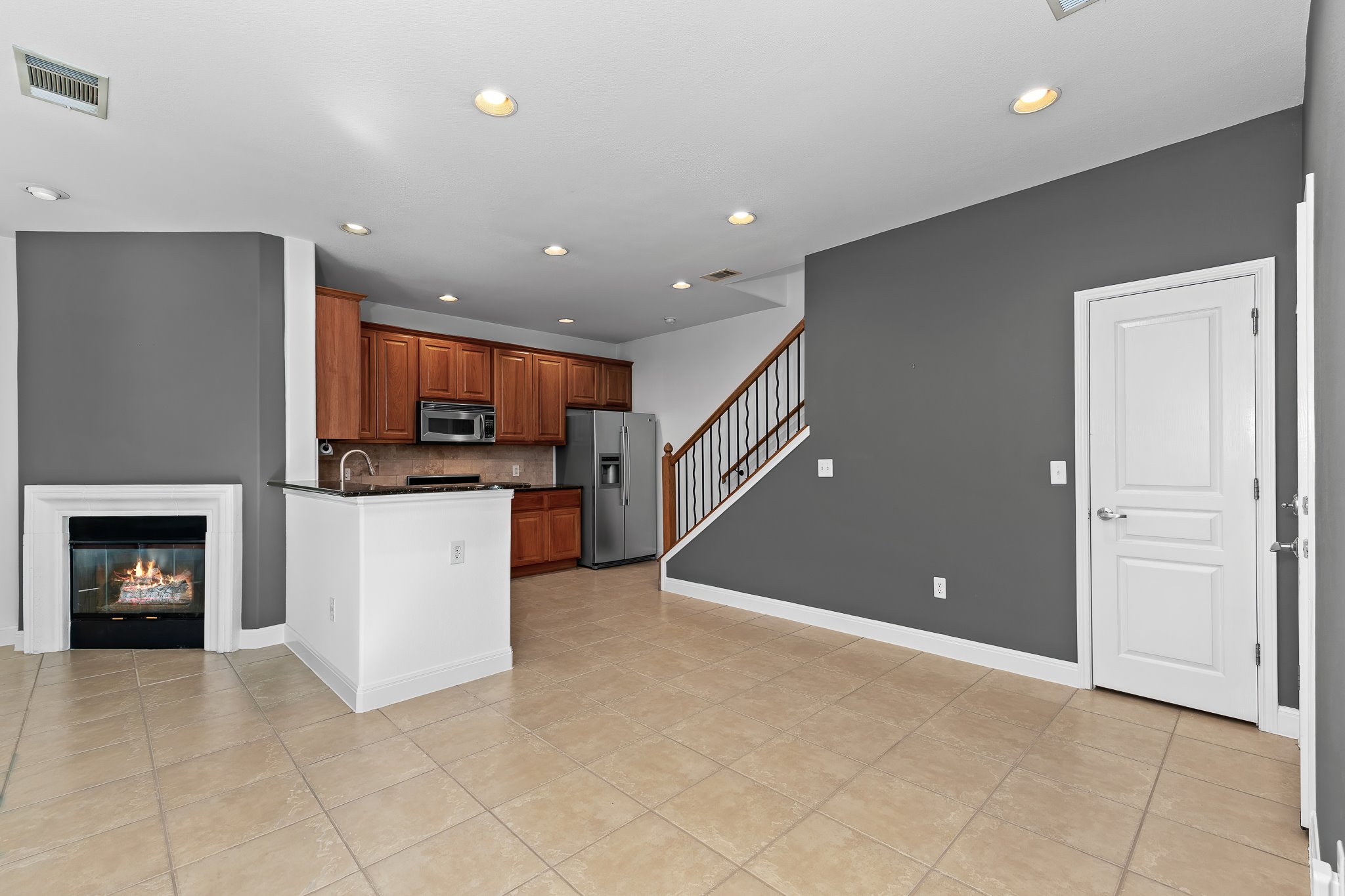3406 Menchaca Road, Unit 28 Austin, TX 78704 - Photo 9 of 40 Kitchen with wood finish cabinetry, a glass covered fireplace, stainless steel appliances, recessed lighting, and a peninsula