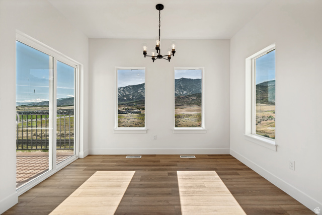 1351 Maple Circle Santaquin, UT 84655 - Photo 15 of 42 Spacious room featuring wood-finish flooring, white walls, and a contemporary black chandelier