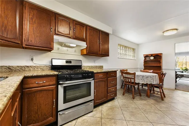 a kitchen with granite countertop wooden cabinets and stainless steel appliances