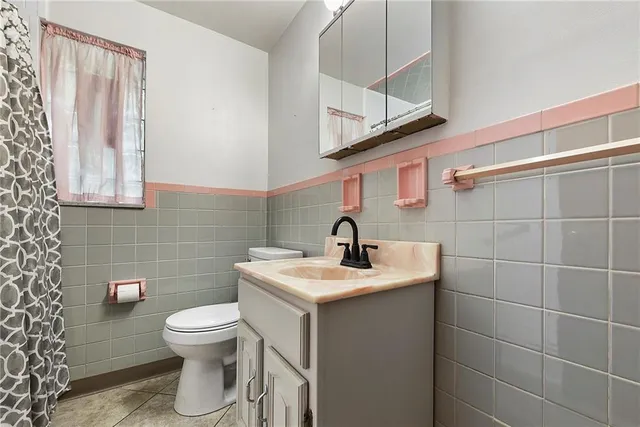 a bathroom with a toilet a sink and mirror