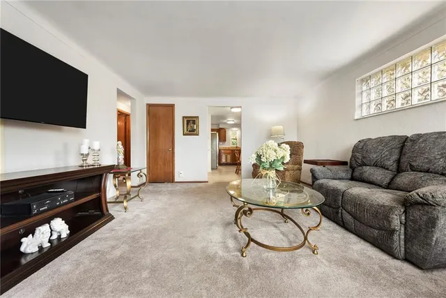 a living room with furniture a flat screen tv and a window