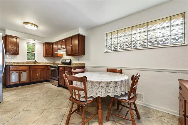 a kitchen with stainless steel appliances granite countertop a sink a stove a microwave a dining table and chairs