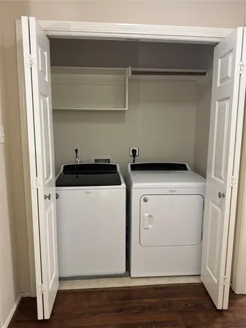 a utility room with wooden floor washer and dryer