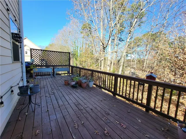 a balcony with wooden floor table and chairs