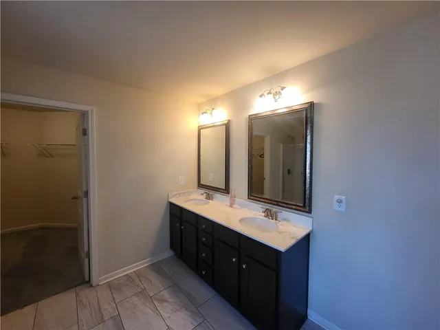 a bathroom with a double vanity sink and a mirror