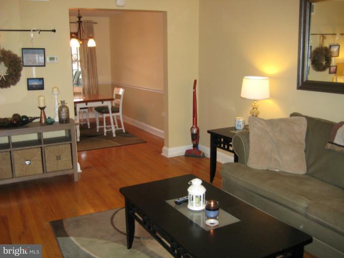 426 Stemmers Run Road Baltimore, MD 21221 - Photo 14 of 21 a living room with couches coffee table and a lamp with wooden floor
