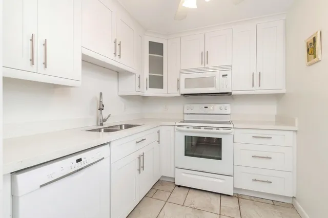 a kitchen with white cabinets and white appliances