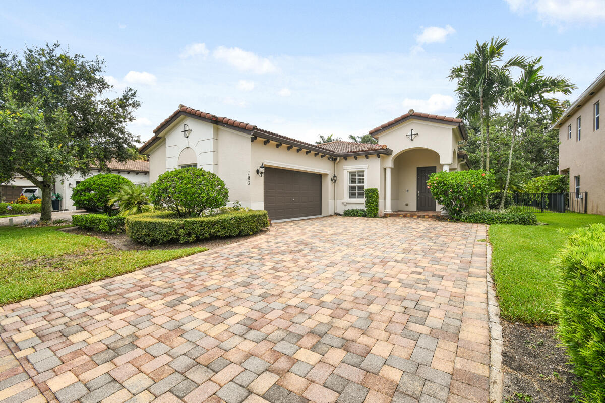 193 Porgee Rock Place Jupiter, FL 33458 - Photo 36 of 76 a front view of a house with a yard and potted plants