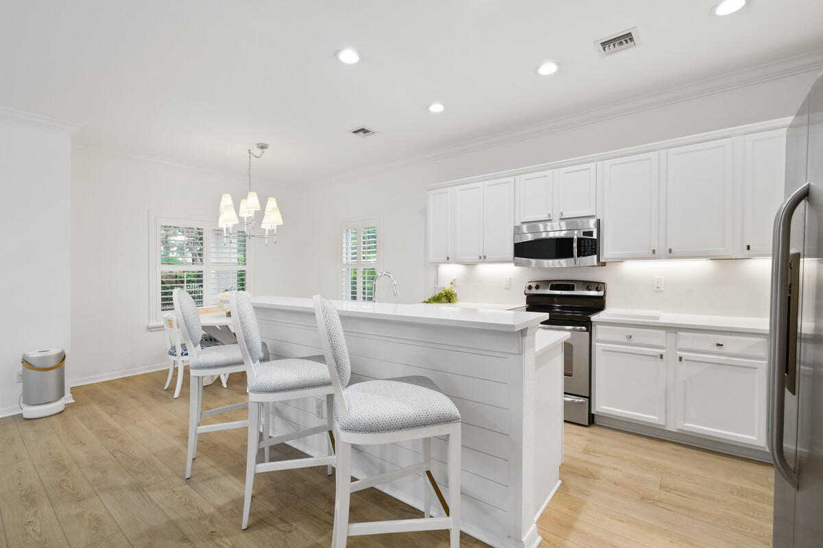 193 Porgee Rock Place Jupiter, FL 33458 - Photo 8 of 76 a kitchen with stainless steel appliances a stove a sink dishwasher a refrigerator with white cabinets and wooden floor