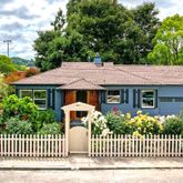 a view of a house with a small yard and wooden fence