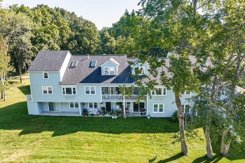 64 Esker Road, Unit 2 Hampton, NH 03842 - Photo 18 of 33 a view of a house with a big yard plants and large trees