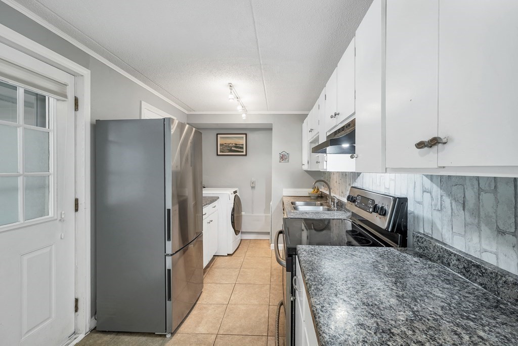 64 Esker Road, Unit 2 Hampton, NH 03842 - Photo 6 of 33 a kitchen with stainless steel appliances granite countertop a refrigerator and a stove top oven