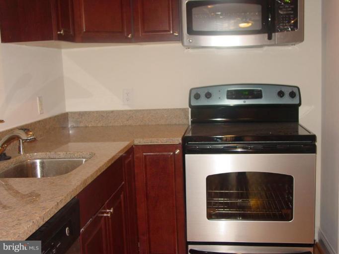 13 S Street Northeast, Unit A Washington, DC 20002 - Photo 5 of 8 a kitchen with granite countertop a stove and a sink