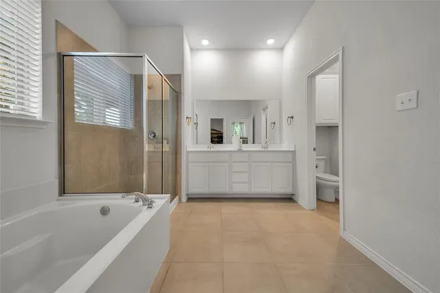 a bedroom with a bed and a flat tv screen on dresser