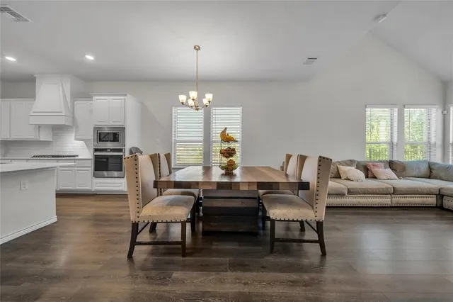 a large kitchen with stainless steel appliances lots of counter space and wooden floors