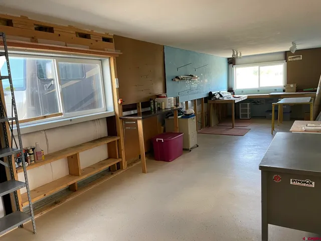 a living room with furniture a flat screen tv and kitchen view