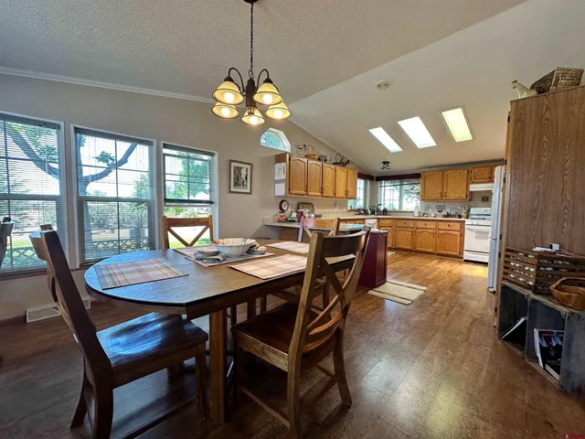 a view of a dining room with furniture a chandelier and wooden floor