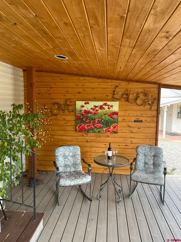 a balcony with chairs and wooden floor