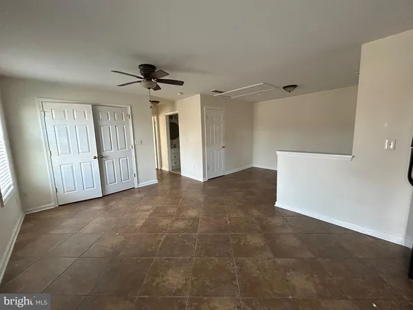 a view of a livingroom with a ceiling fan & windows
