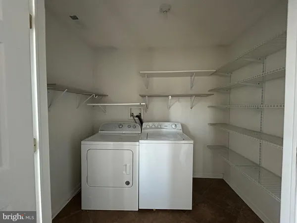 a utility room with cabinets washer and dryer