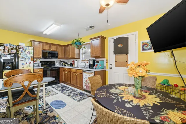 a kitchen with stainless steel appliances granite countertop a stove a sink dishwasher a dining table and chairs with wooden floor