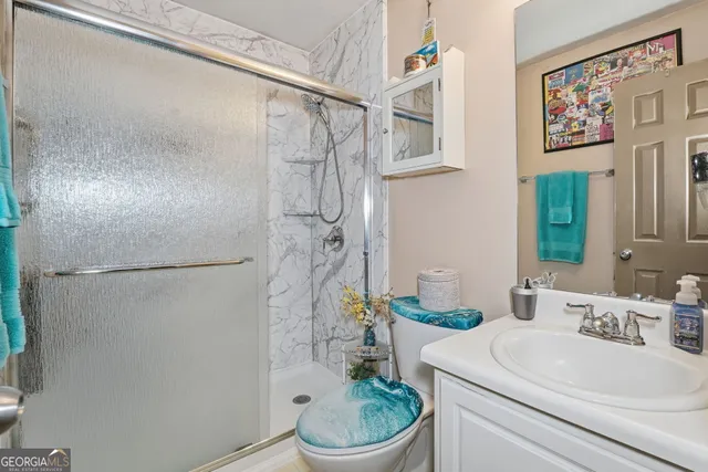 a bathroom with a sink a toilet and shower