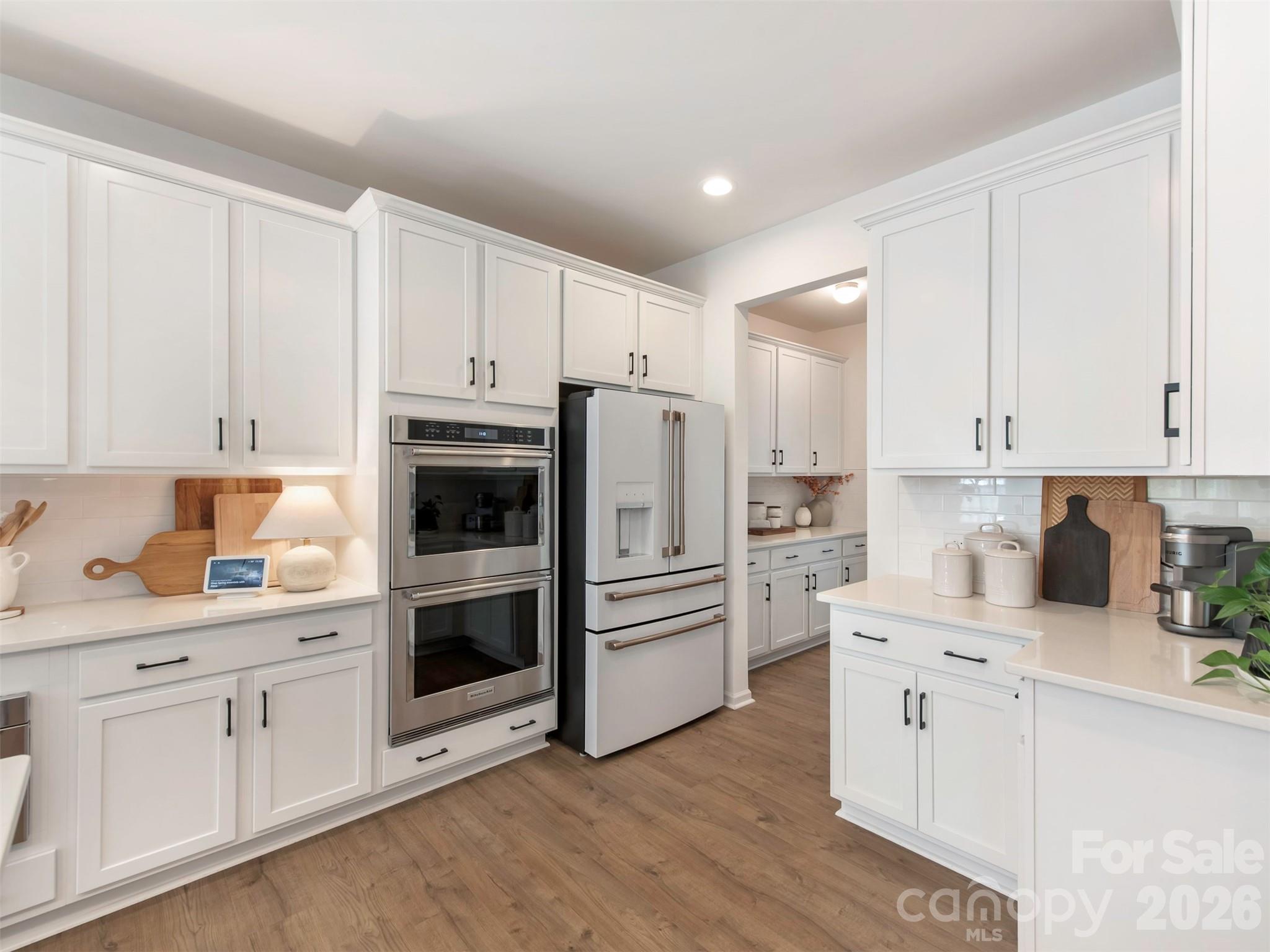 966 Scotch Meadows Loop Monroe, NC 28110 - Photo 12 of 48 a kitchen with white cabinets and white appliances