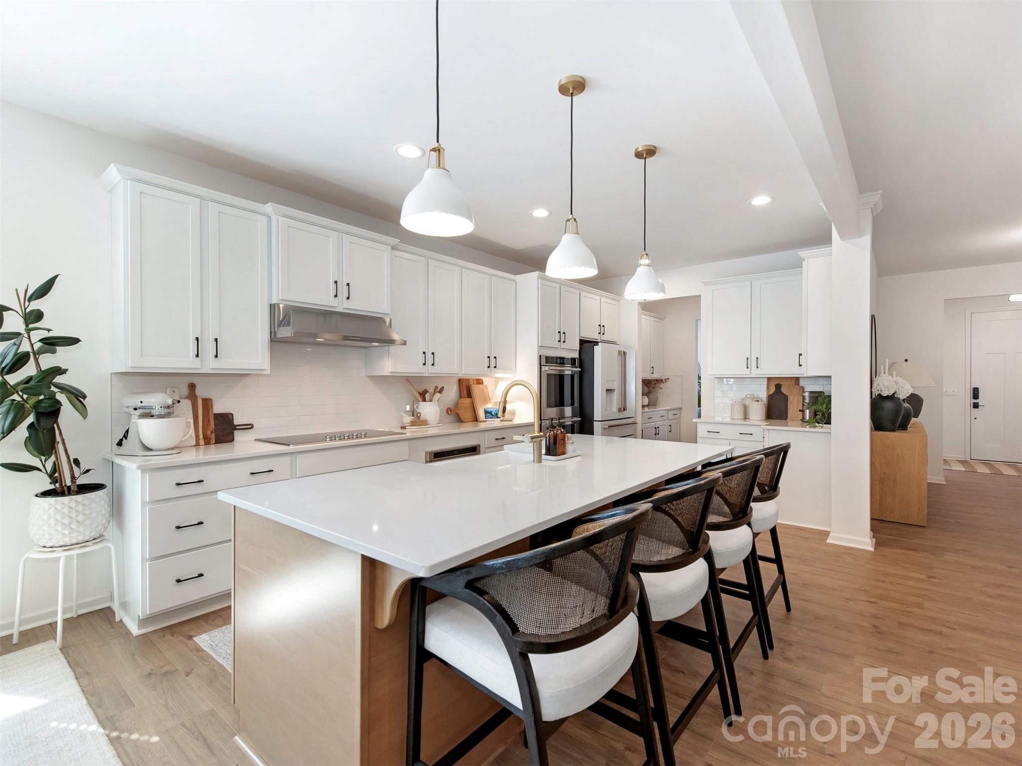 966 Scotch Meadows Loop Monroe, NC 28110 - Photo 14 of 48 a kitchen with stainless steel appliances kitchen island granite countertop a table chairs sink and cabinets