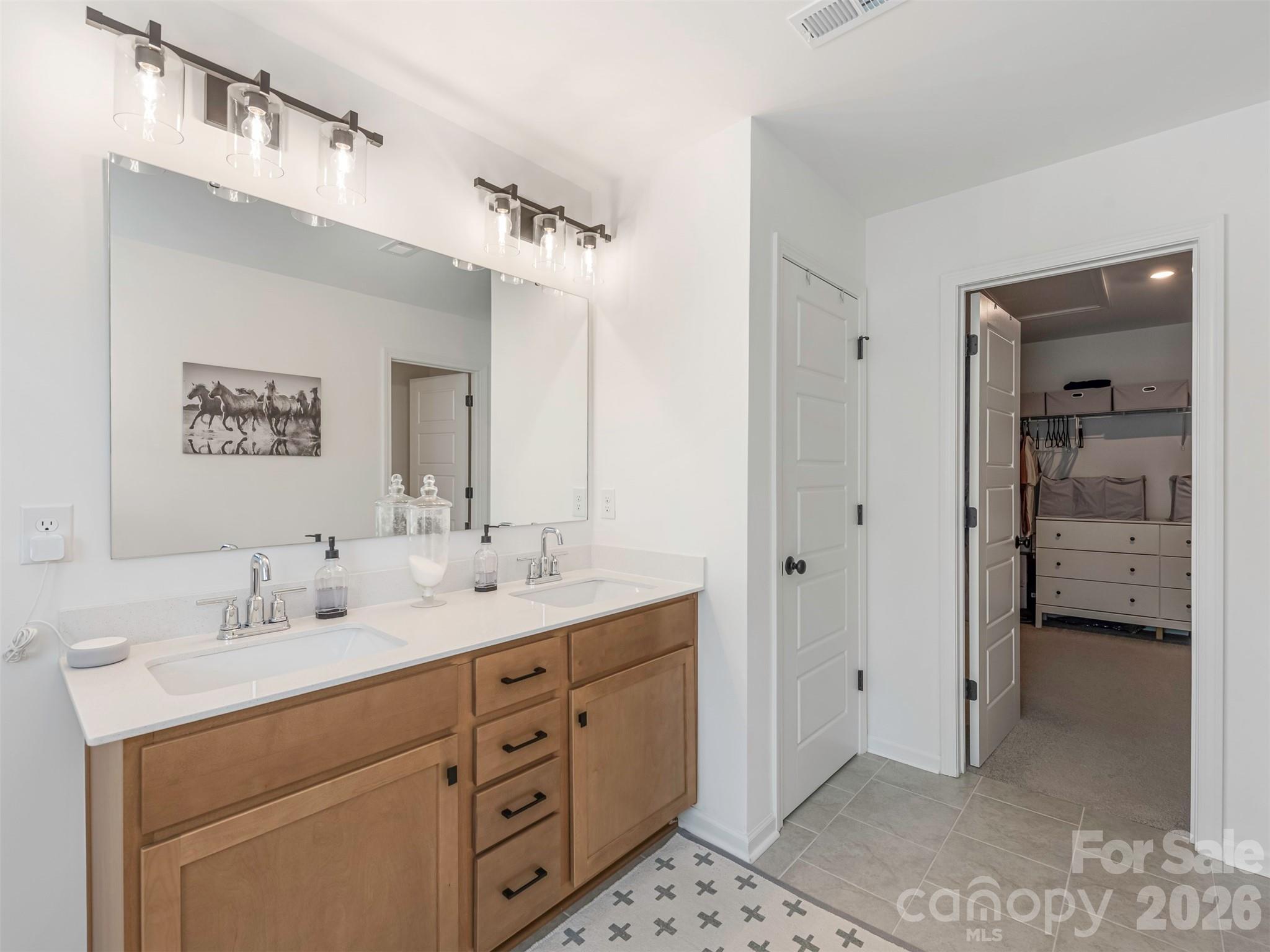 966 Scotch Meadows Loop Monroe, NC 28110 - Photo 25 of 48 a bathroom with a double vanity sink a mirror and a shower