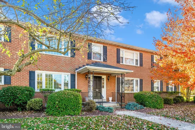 front view of a brick house with a yard