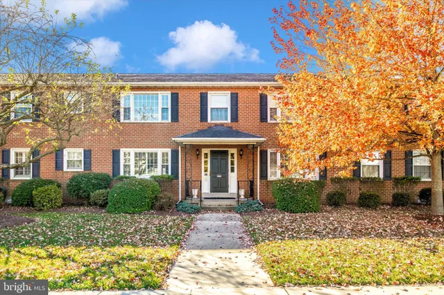 front view of a brick house with a bench and a bench