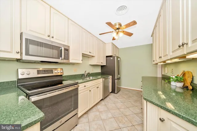 a kitchen with stainless steel appliances granite countertop a sink a stove a microwave and cabinets