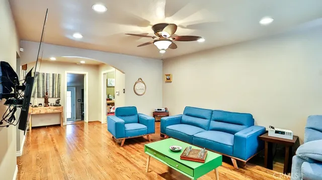 a living room with furniture a ceiling fan and a rug