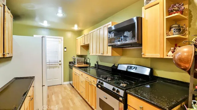 a kitchen with stainless steel appliances granite countertop a stove and a microwave